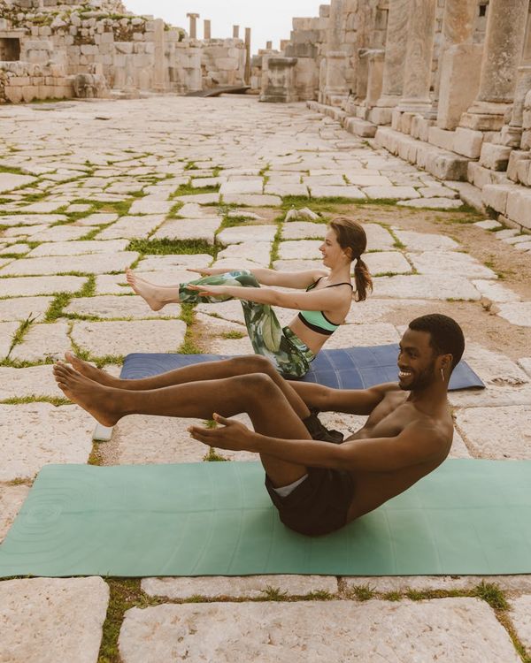 Person of diverse background meditating peacefully on a yoga mat.